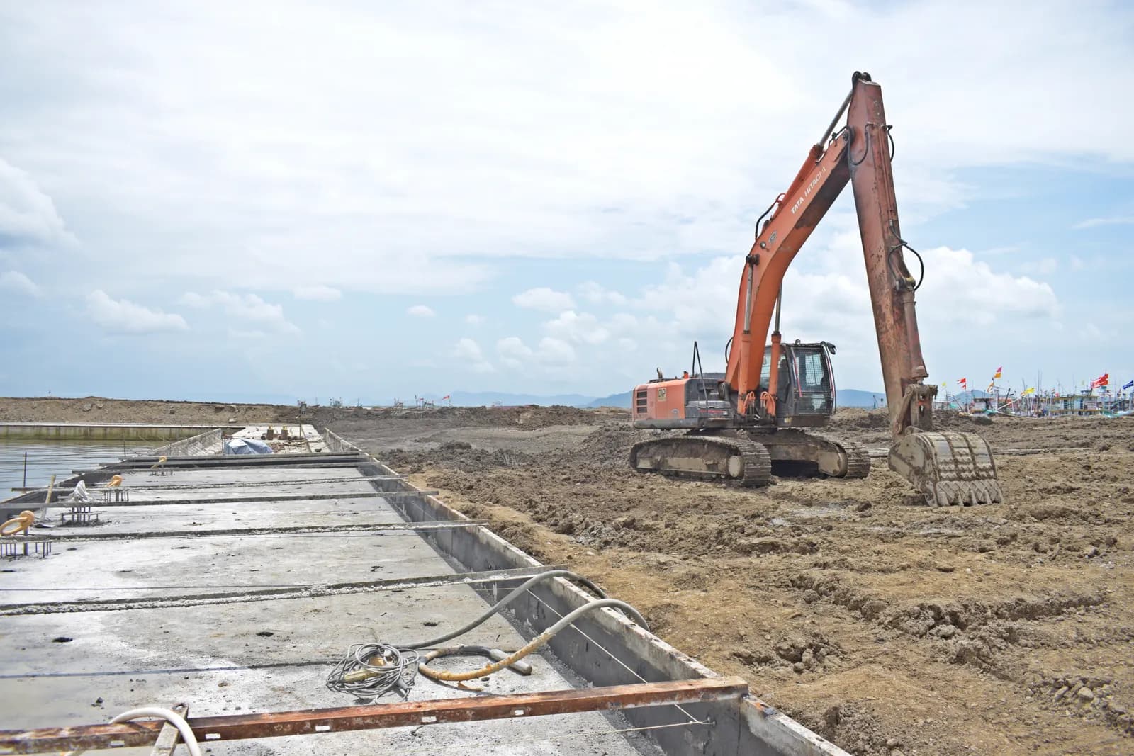 Graafmachine naast betonnen funderingswerk op een bouwterrein