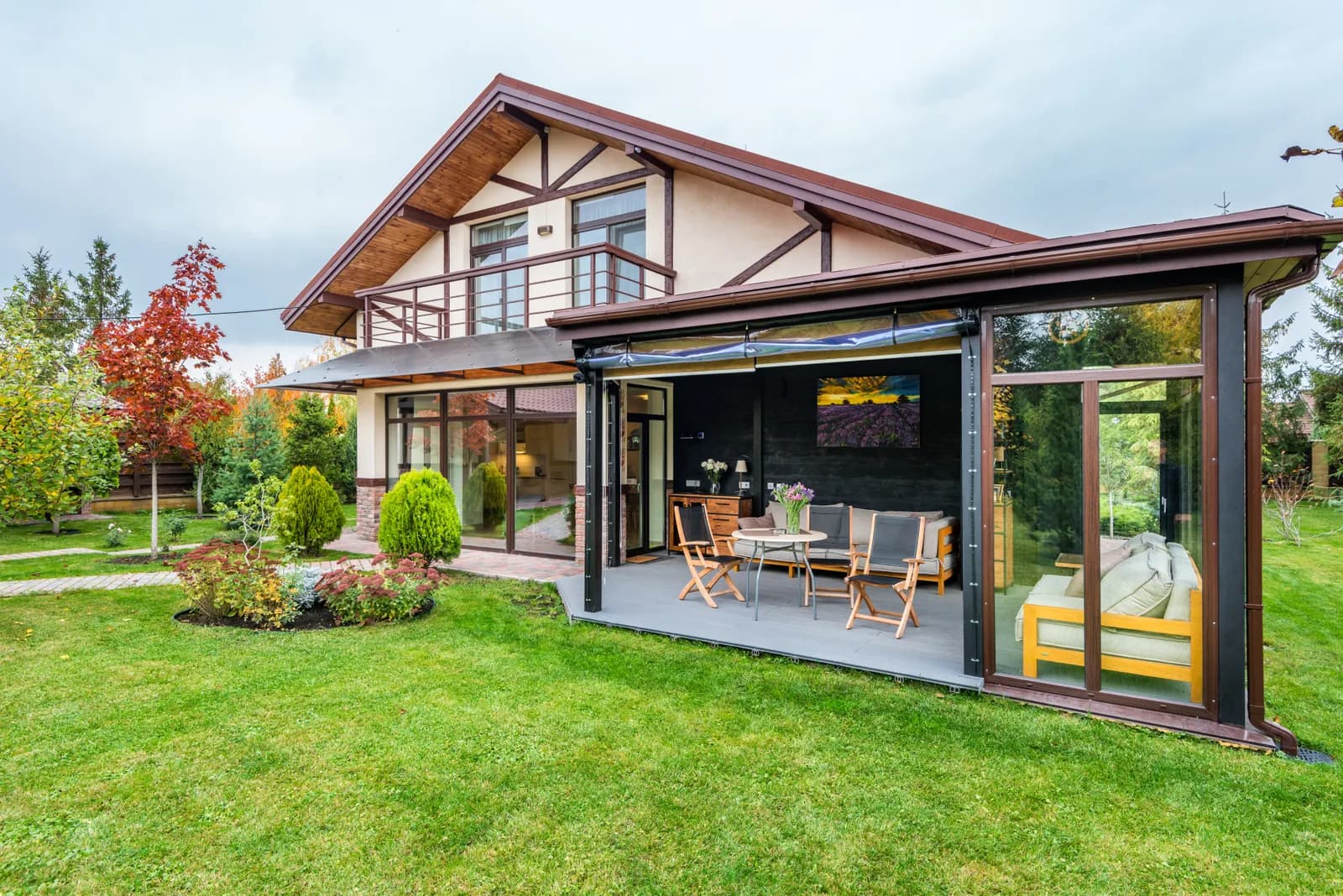 Tuin met gazon, beplanting en terras bij een woning