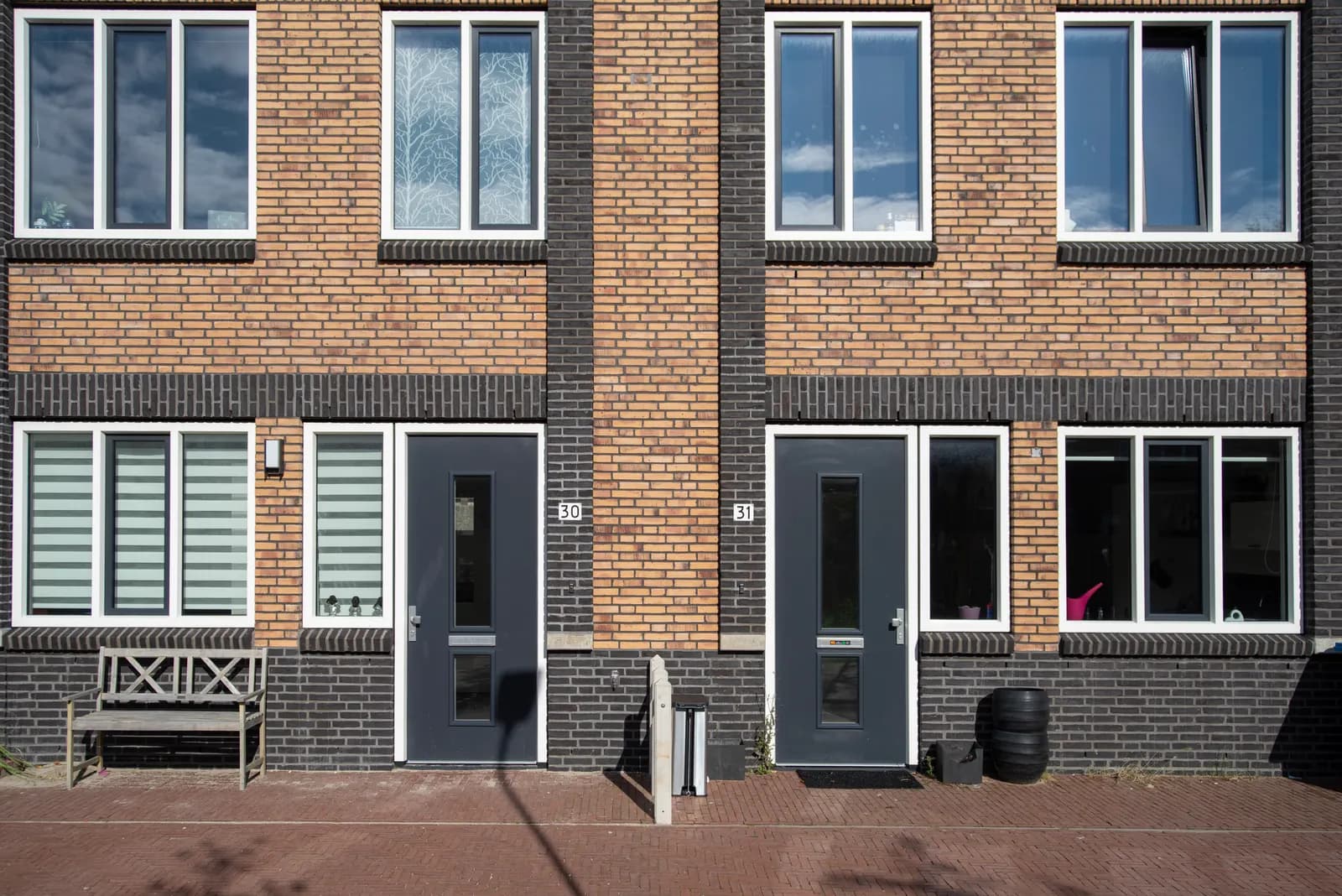 Bakstenen gevel met grote ramen en buitendeuren